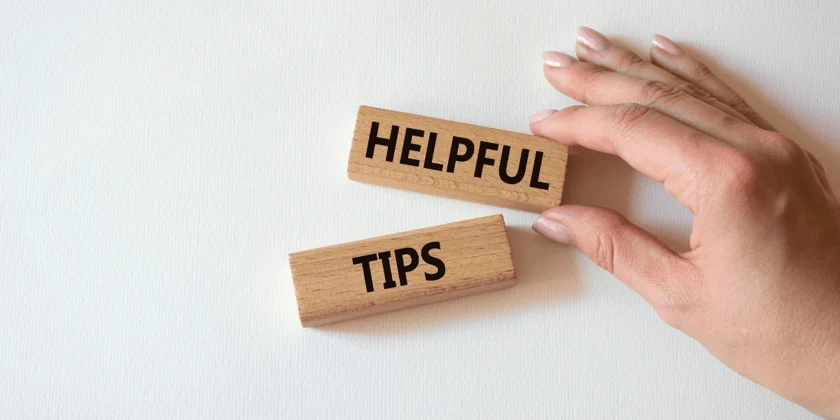 Hand holding two wooden blocks spelling 'Helpful Tips' against a light background, symbolizing useful landlord advice and rental property management strategies